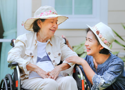 senior woman and caregiver wearing beautiful hats