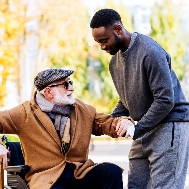 caregiver helping senior man get up